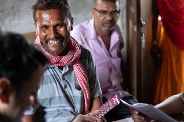 A Nepalese health workers smiles and holds a pack of multi-drug therapy pills. Photo by Andie Tucker