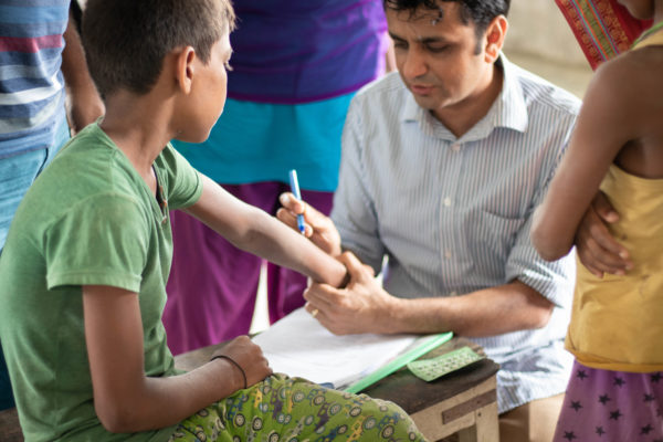 A doctor checks a boy's arm for signs of leprosy. Photo credit: Andie Tucker